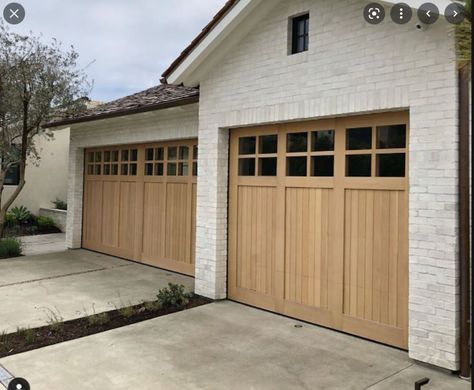 Wooden Garage Doors Farmhouse, White Brick House Wood Garage Door, Wooden Front Door And Garage Doors, Natural Wood Garage Doors White House, Garage Door Ranch Style Home, Nice Garage Doors, Light Brown Garage Door, Modern Ranch Garage Doors, Garage Door Styles Craftsman