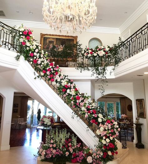 Staircase with Pink Floral Décor | Photo: Courtesy of The Hidden Garden. Flowers Stairs Decoration, Hanging Flowers Over Head Table, Staircase Floral Arrangement, Stairs Flower Decoration Wedding, Flower Staircase Wedding, Stairs Floral Decor, Floral Staircase, Wedding Staircase Decoration Railings, Floral Staircase Wedding