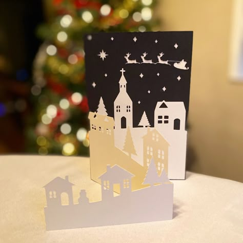 Create your own festive Holiday cards with this Christmas Village Scene SVG files. This template makes beautiful Greeting Cards and is a great project for the whole family! #seasongreetings #holidaycard #christmascard #christmasvillage #christmascene #santasleigh #wintertown #holidaygreeting #christmassvg #holidaycardtemplate #christmascardtemplate #diychristmascard #winterwonderland #diyholidaycard #stampinup #stampinupcards #cricut #cricutmade #cricutcreated #cricutsvg #svg #svgfiles #svgfiles Beautiful Diy Christmas Cards, Silhouette Cameo Christmas Cards, Intricate Christmas Cards, Christmas Village Cards, Paper Cut Christmas Cards, Silhouette Christmas Cards, Pop Up Christmas Cards Diy, Cricut Christmas Cards Ideas, Christmas Card Cricut