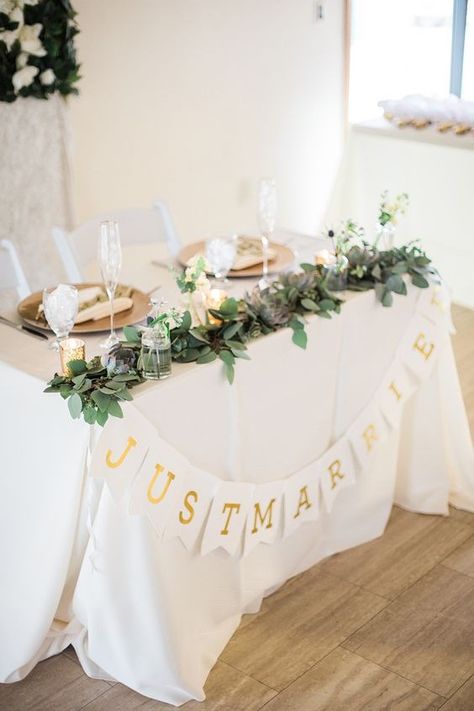 Simple Wedding Table For Bride And Groom, Sweetheart Table With Garland, Garland On Sweetheart Table, Simple Bride Groom Table, Bride And Groom Table Candles, Small Bride And Groom Table, Small Head Table Wedding, Sweetheart Table Garland With Flowers, Bride Groom Table Simple