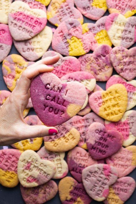 a hand with pink nail polish holding a marble-colored heart-shaped cookie that's purple, pink, and yellow with a message stamped on it that says: can I call you? Pub Desserts, Purple Food Ideas, Colored Sugar Cookies, Marble Sugar Cookies, Heart Sugar Cookies Recipe, Vegetarian Cookie Recipes, Vegan Party Food Ideas, Cookie Recipes Vegan, Marble Cookies