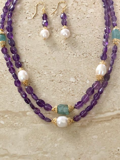 Amethyst Necklace featuring 2 strands of oval faceted amethyst stones accented with gold over copper Bali style bead caps accenting freshwater pearls and neon apatite stones.  Gold filled toggle clasp.  Necklace measures 18 inches.  Matching earrings with gold filled ear wires. Handmade. Pearl And Amethyst Necklace, Toggle Clasp Necklace, February Birthstone Necklace, Knot Jewelry, Beaded Necklace Designs, Amethyst Stones, Bali Style, Jewelry Knots, Purple Jewelry