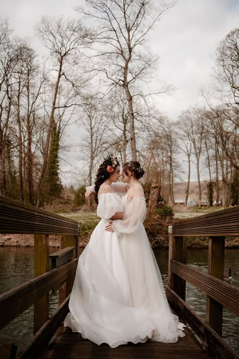 Two brides on the bridge at Mapledurham in ethereal wedding dresses with flower crown and hair vine bridal accessories Wedding Dresses Lesbian Couple, Two Bride Wedding, Lesbian Garden Wedding, Lesbian Wedding Dress, Two Brides Wedding, Lgbtq Wedding Two Brides, Sapphic Wedding, Lesbian Wedding Outfits, Wlw Wedding