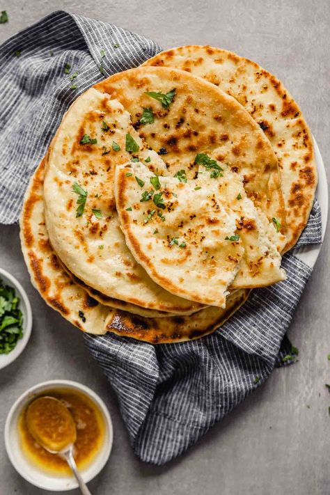 Soft and chewy homemade garlic naan bread! This is the EASIEST yeasted bread you will ever make. It’s addictively soft and full of flavor from garlic and browned butter. Learn how to make this skillet bread with a simple-to-follow recipe, step shots and cooking video. Naan Photography, Naan Recipe Without Yeast, White Food Photography, Garlic Naan Bread, Garlic Naan Recipe, Best Baked Goods, Pane Naan, Cheese Naan, Bread Photography