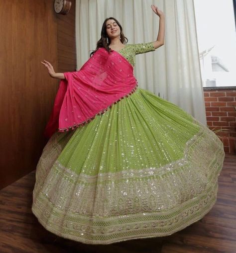 Grand lehenga choli adapté comme vêtement d'invité de mariage, tenue mehendi ou haldi, convenant comme vêtement de fête et occasionnel. Matière : georgette Couleur : vert et rose rani Broderie : Gota zari, fil de soie et sequins Choli : tissu georgette travaillé avec broderie Détails Lehenga : 3,50 mts avec flare, cancan et toile inclus Dupatta : tissu georgette rose rani travaillé avec des motifs épars. Comprend des glands sur les deux côtés du dupatta Tailles : vous pouvez choisir dans la sect Pista Color Lehenga Combination, Mehendi Outfits Sisters, Grand Lehenga, Dark Green Lehenga, Party Wear Long Gowns, Function Dress, Indian Outfits Modern, Lehenga Ideas, Green Lehenga Choli