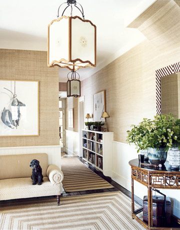 The Entryway  In the entrance hall, stripes of every stripe: on the settee, the hand-stenciled sisal rug, and the custom mirror frame. Lanterns from John Rosselli. The bookcase, built in to break up the long hallway, is lifted to create a sense of more floor space. Veranda Design, Look Wallpaper, Hall Rugs, Room Redo, Grasscloth Wallpaper, Updating House, A Living Room, Wainscoting, Architectural Digest