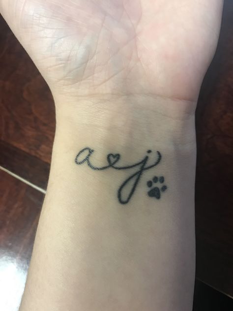 Initials and paw print wrist tattoo 🖤🐾 Wrist Tattoos Initials, Dog Initial Tattoo Ideas, Paw Print Tattoo With Initial, Tattoos With Initials, Letter L Tattoo, Tattoos Initials, Tattoos Cute, Dog Paw Tattoo, M Tattoos