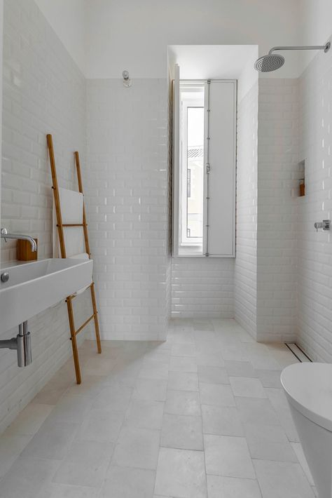 White tiles — hydraulic ones on the floor and “biselado” (meaning “beveled”) ones on the walls — make for a tranquil bathroom. White Tiled Bathroom, Large White Tiles, Unique Bathrooms, Tranquil Bathroom, Minimal Apartment, Tiled Bathroom, White Bathroom Tiles, White Subway Tiles, Bad Inspiration