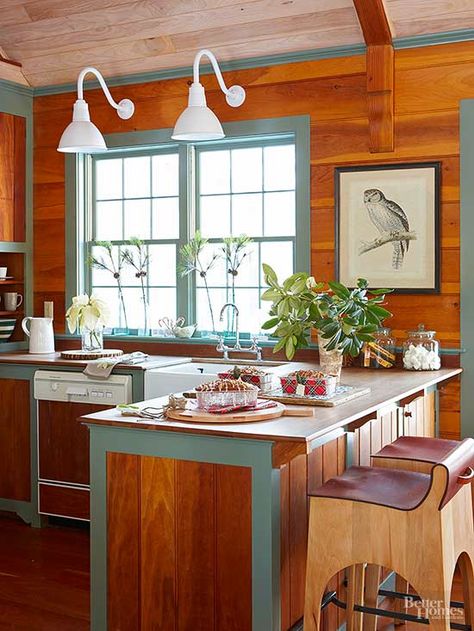 Bright white fixtures bring a sense of fun to the wood-clad wall behind this kitchen's sink. Their goose-neck forms are reminiscent of study lights, their color is cheerful, and their overall design reflects the eclectic kitchen's blend of natural and sleek surfaces with traditional design elements. / Kitchen Rustic Modern, Cabin Style Kitchen, Panel Walls, Kitchen Decor Lighting, Rustic Light Fixtures, Kitchen Rustic, Vintage Cabin, Eclectic Kitchen, Woodland Decor