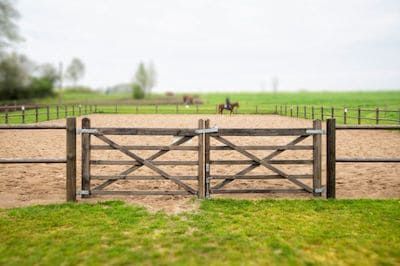 Building A Riding Arena At Home: Step-by-Step Guide Horse Riding Arena, Riding Arena, Horse Arena, Wooden Gate, Indoor Arena, Horse Fencing, Riding Arenas, Horseback Rider, Things To Keep In Mind