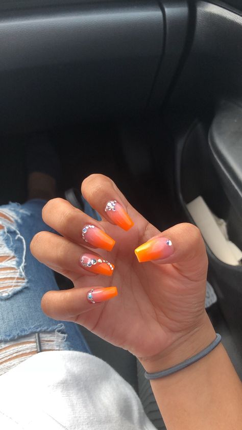 Orange Nails With Jewels, Coral Orange Nails Acrylic, Short Orange Nails With Rhinestones, Bright Summer Nails With Rhinestones, Summer Nails Diamonds, Orange Ombre Nails With Design, Neon Orange Prom Nails, Orange Nails Ideas Short, Ombre Orange Acrylic Nails