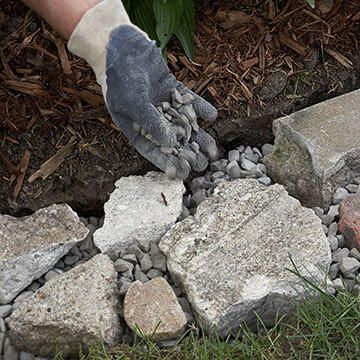 Position the rubble or fieldstones at ground level with flat sides up. Add gravel under pieces as needed to create a level surface. Leave 1-inch-wide or larger gaps between the pieces. Sprinkle gravel into the gaps until they're mostly filled and the area is level. Mowing Strip, Garden Edge, Fern Gully, Garden Walkways, Broken Concrete, Outdoor Gardens Landscaping, Garden Walkway, Landscape Edging, Lawn Edging