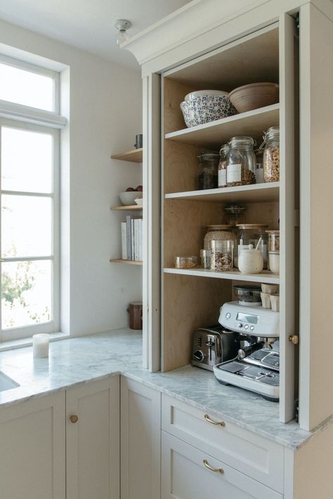 “I really love our pocket doors on the pantry. It’s a hidden coffee station, and I love being able to open those up while we’re making coffee or getting the kids’ lunches packed. It would have made the kitchen feel really closed off and awkward if they didn’t slide in the way they do.” Kitchen Design Without Windows, Small Charming Kitchen, Pocket Door Pantry Cabinet, Pocket Door For Pantry, Kitchen Cabinet Hidden Door, Hidden Cabinet Doors, Cozy Kitchen White Cabinets, Pocket Door Cabinets, Hidden Kitchen Bar