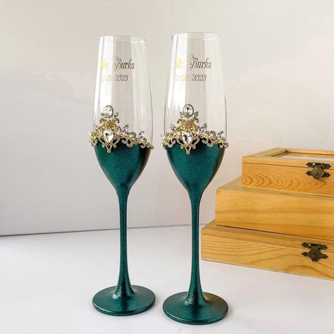 Emerald wedding items perfectly matches with gold decor and white stones. These flutes and a cake set create for the floral wedding.  In addition to the flutes and cake set we suggest a decorated plate and forks for wedding cake.  Aslo we create unity candle set with candleholders to supplement this royal wedding set. ATTENTION Please, choose the script for engraving. (See in Photoes of the Listing) If you don't do this, the engraver makes a standart script(№ 4) Please, double chek the text for engraving Olive Green Decor Wedding, Wedding Ideas Emerald Green And Gold, Emerald Green Quince Center Piece, Emerald Wedding Centerpieces, Green And Silver Wedding Cake, Royal Green Wedding, Emerald Green And Rose Gold Wedding, Quince Cups, Emerald Green And Gold Wedding Theme