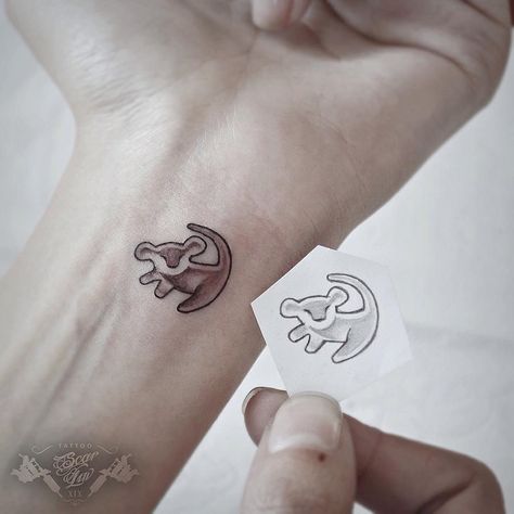 Makeup, Beauty, Hair & Skin | 12 Tiny Simba Tattoos For Those Who Just Can't Wait to Be King | POPSUGAR Beauty Matching Disney Tattoos, Lion King Tattoo, Petit Tattoo, Mouse Tattoos, Tattoo Trend, Shape Tattoo, King Tattoos, Sibling Tattoos, Cat Tattoos