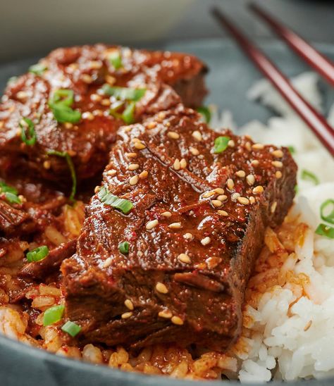 Close-up of two large pieces of Korean beef stew garnished with sesame seeds and green onions. Korean Beef Stew Recipe, Korean Beef Stew, Korean Stew, Korean Beef Recipes, Braised Short Ribs Recipe, Stew Beef, Beef Ribs Recipe, Ground Beef And Potatoes, Korean Beef