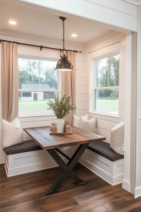 Cozy breakfast nook with a wooden table, pendant light, and corner bench seating adorned with cushions. Breakfast Bench Ideas, Breakfast Nook Against Wall, Large Breakfast Nook Ideas, Breakfast Nook Square Table, Farmhouse Bistro Table, Dining Nook With Windows, Diy Kitchen Breakfast Nook, Building A Breakfast Nook, Built In Booth Dining Room