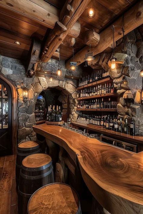 A rustic wine cellar bar featuring stone archways, a polished wooden countertop, and barrel-style stools. The walls are lined with shelves full of wine bottles, creating a cozy, inviting atmosphere for wine lovers. Rustic Bars For Home, Wood Bar Countertops, Wine Cellar Design Rustic, Wine Barrel Bar Ideas, Barrel Bar Ideas, Rustic Wine Cellar, Sedona House, Rustic Home Ideas, Whiskey Bars