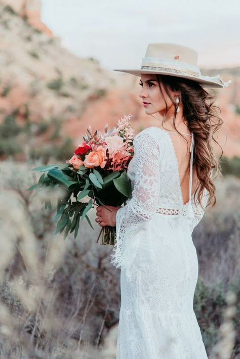 Elopement Dresses Guide Cheap Wedding Dress Options for Elopements | https://wanderingweddings.com/elopement-dresses/ Hats With Wedding Dresses, Boho Wedding Hair Hat, Wedding Dress With Wide Brim Hat, Wedding Cowboy Hats For Bride, Wedding Dress And Cowboy Hat, Wedding Dresses With Hats, Wedding Dress With Hat Boho, Bridal Hat Boho, Bridal Hair With Hat