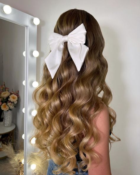 This half-up, half-down hairstyle features voluminous, soft curls with a large white bow, adding a playful yet elegant touch. The bow enhances the femininity of the style, making it perfect for romantic dates or festive celebrations. Half Up Half Down Curled, Soft Curl Hairstyles, Cute Curly Hairstyles, Bow Hairstyle, Winter Event, Half Updo, Bow Making, Soft Curls, Romantic Dates