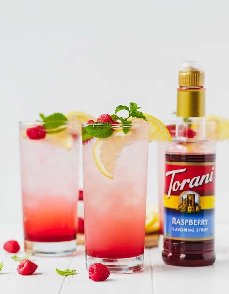 Sparkling raspberry lemonade in tall clear glasses with a bottle of torani syrup next to them Sweet 16 Breakfast Ideas, Single Serve Lemonade Recipe, Torani Syrup Recipes, Torani Recipes, Soda Stream Recipes, Cream Of Pumpkin Soup, Monin Syrup, Raspberry Drink, Kids Drinks