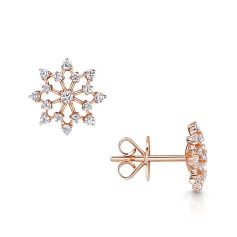 Depicting the beauty of a delicate falling snowflake, these elegant diamond stud earrings feature an open design adorned with beautiful round brilliant cut diamonds for adding a touch of panache to any outfit. The earrings have been crafted from 18ct rose gold and feature a surface polish that enhances the radiance of each specially chosen diamond in their settings. These rose gold diamond snowflake earrings have been crafted meticulously by skilled craftsmen. Attention to detail can be admired