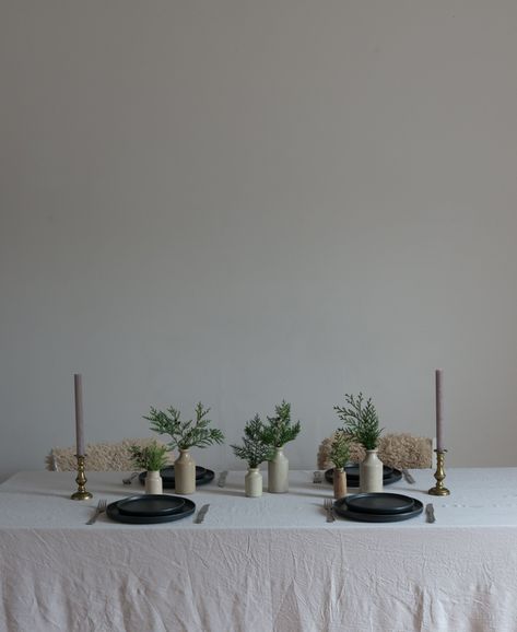 Christmas place setting ideas. Simple evergreen foliage on vijtage stoneware vases. sheepskins on chairs and simple candles in brass vintage candlesticks. cosy minimalist chrstmas table Christmas Place Setting Ideas, Minimalistic Table Setting, Table Dressing Ideas, Soulful Christmas, Christmas Place Setting, Christmas Wedding Table, Place Setting Ideas, Christmas Place Settings, A Thoughtful Place