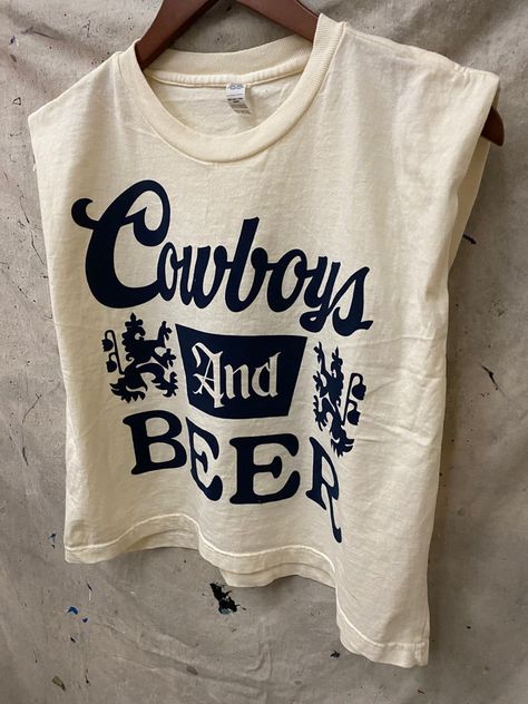 Country Deep Cowboys and Beer Logo Boxy Cropped muscle top 6 oz./yd², 100% cotton, garment-dyed, 18 singlesGarment-dyed for that vintage, faded look and almost no shrinkage at homeBoxy fit, slightly croppedWide rib collarTaped neck and shoulders for comfort and durabilityStructured shoulders Body Length 20 21 22 23 24Body Length Tolerance +/-1 +/-1 +/-1 +/-1 +/-1Chest Tolerance +/-1 +/-1 +/-1 +/-1 +/-1Chest Width (Laid Flat) 21 22 23 24 1/2 26 Country Clothing Brands, Clothing Designer Aesthetic, Vintage Beer Shirts, Graphic Crop Tops, Nashville Style, Baby Crop Top, Beer Logo, Concert Fits, Sweatshirt Short Sleeve