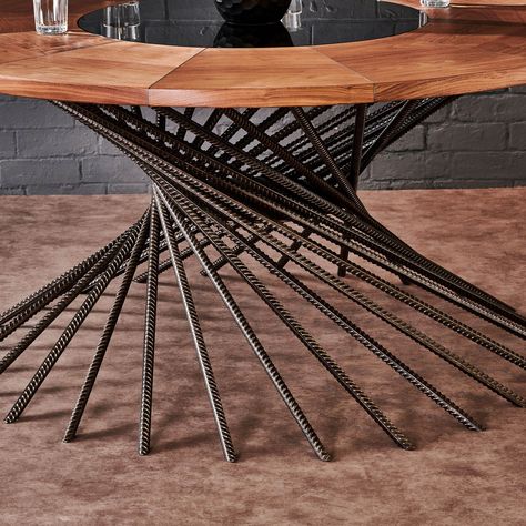 Bespoke with the beauty of natural hardwood timber, this industrial style round table features a stunning architectural element with a swirled design of rebar post legs. The UK forged steel rebar base appears spiralled, as if it’s rippling in the wind, while the 35mm American black walnut tabletop sets the foundation. A circle of 10mm thick tinted tempered glass sets the stage at the centre. This fine dining table will be a treasure to behold in a family’s legacy. It’s fully designed and crafted Metal Table Base Ideas, Metal Frame Table With Wood Top, Timber Table Metal Frame, Forged Steel Table Base, Industrial Round Meeting Table, Steel Table Base Bar Height, Rustic Industrial Furniture, Round Metal Table, Welded Furniture Table & Bar Stools