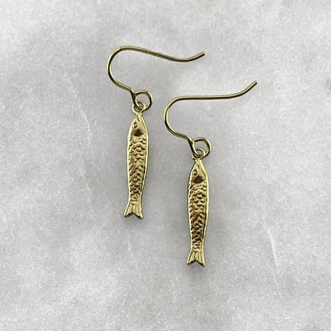 A fish symbolizes fertility, feelings, creativity, rebirth, good luck, transformation, health, abundance, serenity, intelligence, happiness, strength, and endurance. Connecting us with the water element, it represents the deeper awareness of the unconsciousness or higher self. Gold plated solid 925 sterling silver or 925 sterling silver fish hook earrings. Fish measures 2cm in length. Material : Sterling Silver, 24k Gold Plate. Each piece is handmade to order in the Jewel Thief Brighton atelier. Gold Earrings Delicate, Gold Fish Earrings, Fish Earrings Gold, Funky Gold Earrings, Cool Gold Earrings, Fish Earing, Sardine Earrings, Health Abundance, Gold Fish Necklace