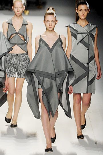 Issey Miyake fall 11 - origami, I like this because she uses triangles to create a big shape, I like that the colours are black and grey because they look shiny, the colour would also stand out on any skin clout which I like because it will suit anyone, I like that in most of her work she's stuck to the same triangle subject Fashion Origami, Mode Origami, Structured Fashion, Architectural Fashion, Origami Ball, Zero Waste Fashion, Origami Fashion, Sculptural Fashion, Origami Rose