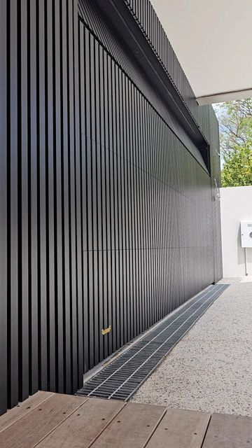 TOWER GARAGE DOORS AUSTRALIA on Instagram: "The sleekest and stylish entrance. Discover our sleek flush mount textura black 40x20 batten sectional door." Garage Sliding Doors, Black Gates Entrance, Modern Black Garage Door, Garage Doors With Open Slats Residential, Black Plank Garage Door, Modern Steel Garage Door, Moden Garage Door, Garage Doors Ideas, Carport Storage