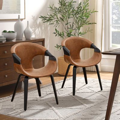 The elegant mid-century modern 2-piece dining chairs are characterized by the curved design with comfortable seating, which can seamlessly complement dining tables. Showcasing special open details, the cozy and welcoming chair embraces a barrel back that flows into armrests and harmoniously combines the seat. The soft foam padded seat perfectly mimics the frame's circular profile and is upholstered in sleek PU leather. Four solid poplar splayed and tapered legs that are sturdy and stable for dai Dining Arm Chair Modern, Mid Century Modern Kitchen Chairs, Mid Century Chairs Dining, Mcm Diy, Cozy Mid Century Modern Living Room, Midcentury Dining Chairs, Mid Century Upholstered Dining Chair, Modern Cabin Interior, Mediterranean Kitchen Design