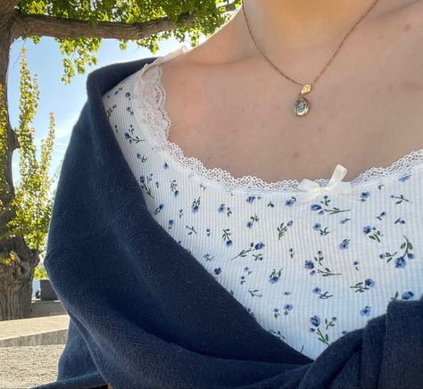 a girl's chest and shoulder wearing a white shirt with a small blue floral pattern, a gold locket, and a blue sweater tied around her shoulders Coastal Granddaughter Aesthetic Outfit, Blue Summer Outfits, Granddaughter Coastal, Coastal Grandmother Aesthetic, Costal Granddaughter, Grandmother Aesthetic, Blue And White Outfits, Blueberry Girl, Sixth Form Outfits