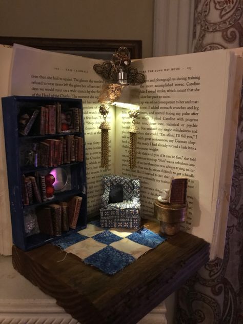 I made this with an old book. Armchair from foam board and fabric. Bookshelf from a small box. Chandelier is a Bacardi bottle cap and earrings. Rug is a quilt piece that my mom gave me. Fabric Bookshelf, Miniature Library, Dollhouse Decorating, Old Book Crafts, Bookshelf Art, Upcycle Books, Doll House Crafts, Miniature Rooms, Book Holders