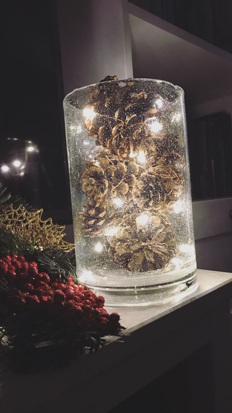 Just 3 items and a few easy steps: 1. Find a glass vase or votive that you like that matches your decor. 2. Get fairy lights - these are from the Target $5 below section. 3. Find pine cones or other decorative filler. I prefer scented pine cones. 4. Wind the fairy lights around the each pine cone and place into the vase. Continue until it is full. Fairy Lights Centerpiece Ideas, Fairy Lights In Vase, Christmas Glass Vase Decor, Pine Cone Centerpiece Wedding, Glass Vase Filler Ideas Christmas, Vase With Fairy Lights, Winter Vase Filler Ideas, Pine Cone Wedding Decorations, Fall Glass Vase Filler Ideas