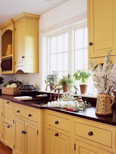 Courageous Yellow:  Feeling that natural wood-tone cabinetry would be too dark for their kitchen, especially during the minimal daylight of Midwestern winters, these homeowners chose cherry cabinets with a golden yellow painted and glazed finish. Now, no matter what the time of day -- or time of year -- stepping into this kitchen is like walking on sunshine. Yellow Kitchen Cabinets, Yellow Cabinets, Country Kitchens, Primitive Kitchen, Yellow Kitchen, Kitchen Cabinet Colors, Wood Countertops, Kitchen Redo, Trendy Kitchen