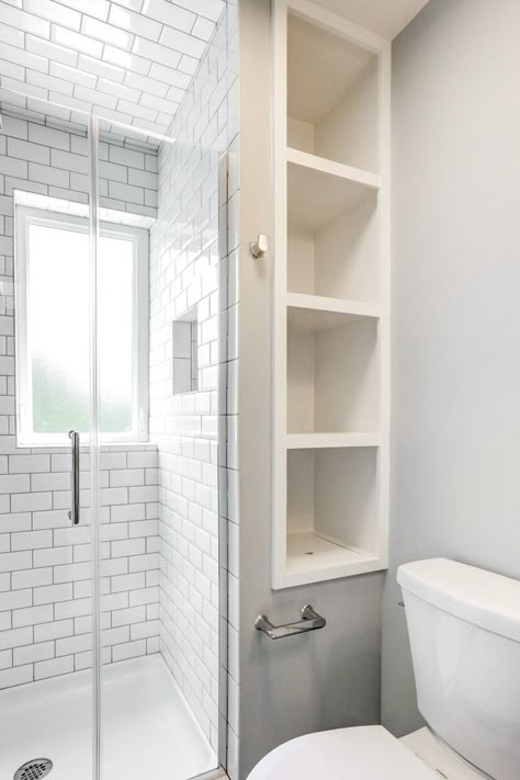 Our designer's inventive plan transformed this bathroom so drastically that it's hard to believe it's the same space. By removing a closet and adding a privacy window, we were able to relocate the shower. Swapping the vanity for a simple pedestal sink made it possible to move the sink across the room, which really opened things up. Recessed shelves in the wall provided the clients with storage without occupying extra floor space. Bathroom Vanity Extra Storage, Bathroom Storage Without Closet, Shower With Side Shelves, Wasted Space In Bathroom, Toilet Between Shower And Vanity, Built In Shelves Next To Shower Stall, Bathroom Inbuilt Shelves, Storage Behind Shower Wall, Cubbies In Bathroom