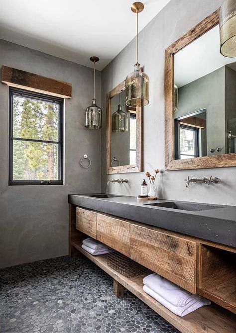 a rustic bathroom with concrete walls, a pebble floor, a rough wood vanity with a concrete countertop, pendant lamps and mirrors Drømme Bad, Bathroom Concrete, Concrete Vanity, Concrete Countertops Bathroom, Countertops Concrete, Pebble Floor, Concrete Bathroom, Concrete Countertops Kitchen, Diy Concrete Countertops