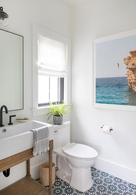 White and blue mosaic floor tiles accent a welcoming powder room featuring a salvaged wood washstand boasting a bronze gooseneck faucet fixed under a black framed mirror. White Powder Room, Pool House Bathroom, Craftsman Style Bungalow, Beachy Bathroom, Beach House Bathroom, Pool Bathroom, House Vibes, Eclectic Interior Design, Coastal Bathrooms