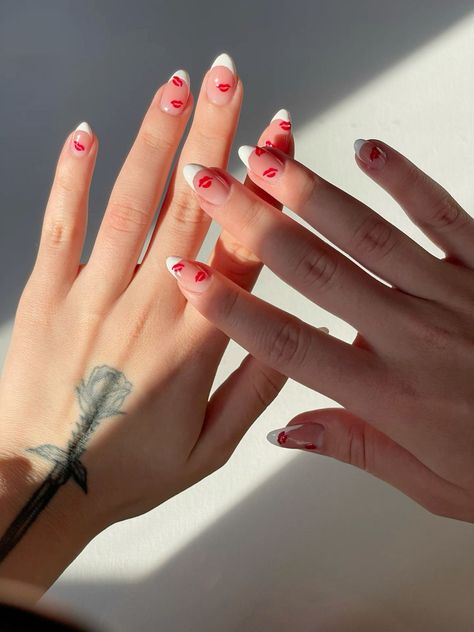 Get ready for Valentine's Day with this romantic nail design featuring white french nails and kisses. Perfect for a cute and festive look on the 14th of February. #KissValentinesNails #FrenchTipsWithKisses #NailDesignsKisses #CuteValentinesDayNailsWithInitial Valentine’s Day Almond Nail Ideas, Kiss Nails French Tip, Nail Designs Kisses, Kiss Day Nail Art, French Kiss Nails, Cute Nails For Red Dress, White Tips Valentines Nails, Kiss Nail Designs Valentines Day, Acrylic Nails Almond Valentines Day