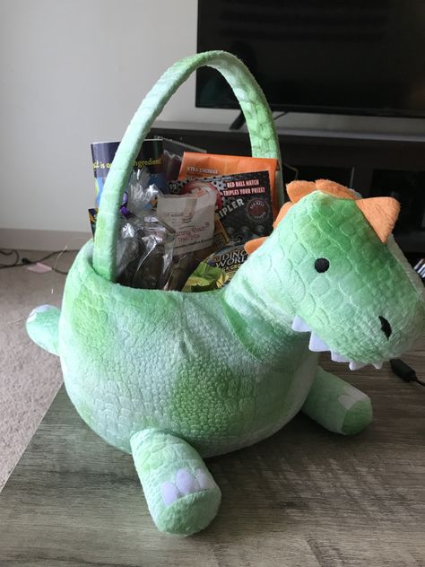 Dinosaur Easter Basket! Filled with all kinds of goodies including a solid chocolate T-Rex and a “grow a Dino” egg. #boyfriendeasterbasket #easter Dino Easter Basket Ideas, Dinosaur Gift Basket, Boyfriend Easter Basket, Dinosaur Easter Basket, Teacher Gift Baskets, Dino Eggs, Birthday Basket, Cute Diy Room Decor, Diy Gifts For Him