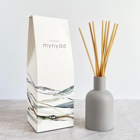 ******NEW LAUNCH****** I’m so thrilled to announce the launch of our new candle and diffuser collection. We’ve been working on this range for a few years now and after a few hiccups earlier in the year we are proud as punch to finally have them here and being received well. There are three scents in the range chosen carefully to evoke the feeling and aromas you may experience in the mountains, the coast and the forest. . Mynydd Môr Coed The packaging is inspired by my studio b watercol... Ceramic Reed Diffuser, Reed Diffuser Packaging, Welsh Words, Ceramic Furniture, Eco Friendly Candles, Textile Wall Art, Ceramic Bottle, Candle Branding, Reed Diffusers