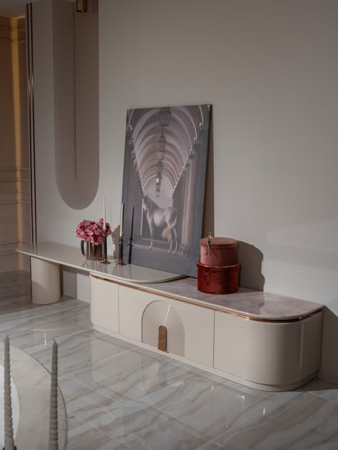 Transform your living space with the Aurelia TV Unit - an epitome of modern luxury. Its opulent blush top, complemented by a chic beige gloss finish and captivating copper accents, creates a visually stunning centrepiece.   	Shop the Aurelia Collection  	240cm x 52cm x 50cm  	Bespoke Made 6-10 Weeks Coffee Table Pouf, Tv Design, Tv Unit Design, Copper Accents, Luxury Dining, Nesting Tables, Tv Unit, Tea Table, Dining Table Chairs