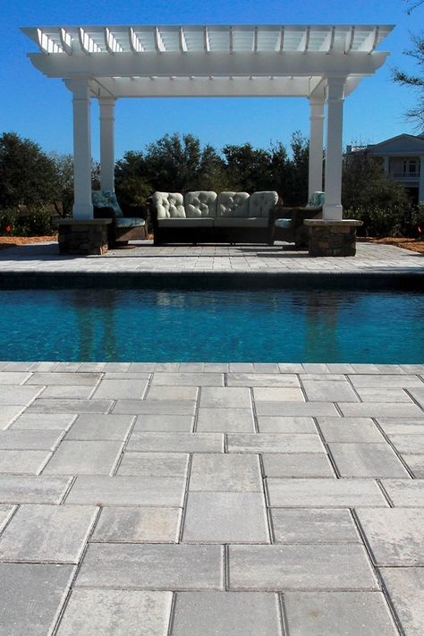 Bahama pavers in Shark Tooth gray by Jackson Landscaping cooly contrast with the alluring blue of the pool at this Landfall residence in Wilmington NC.  Stone Garden can match you with a water garden specialist or a contractor to build your pool and install the stonework that will set it off. Gray Paver Pool Deck, Pool Deck Pavers Ideas, Gray Pavers Around Pool, Concrete Pavers Around Pool, Paver Pool Deck Ideas, Gray Pavers Patio, Landscape Pavers Ideas, Gray Pool Deck, Pool Pavers And Coping