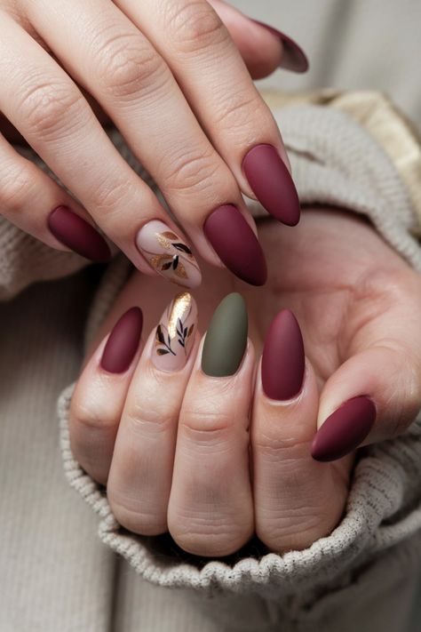 Embrace the season with these elegant matte fall nail ideas that perfectly complement the rich hues of autumn. Imagine deep burgundy and muted mustard shades finished with a velvety matte topcoat, providing a sophisticated touch to your fall style. This nail design is not only trendy but also an expression of warmth and coziness. Don't miss out on these stunning matte fall nail ideas for your next manicure! Oval Nails Designs Matte, Green And Maroon Nails, Maroon Autumn Nails, Fall Season Nails Matte, Matte Burgundy Nails Design, Dark Maroon Matte Nails, Matt Burgundy Nails, Autumn Nails Matte, Matte Burgundy Nails