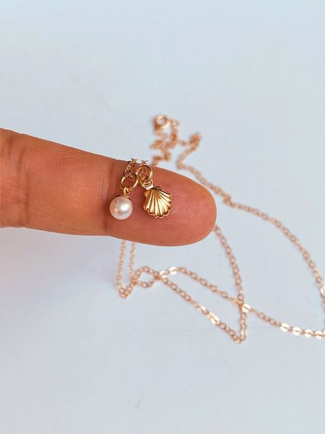 14k gold tiny seashell pearl necklace. Super cute and Super tiny charms.  This is a super, super cute necklace. It's is very simple and perfect with any outfit . This beautiful necklace consists of... -6x8.5mm 14kSea Shell Charm, -14k gold tiny pearl charm, -14k Solid gold rope chain, cable chain , or box chain, -Come up with beautiful ribbon gift box and -One set of Care instruction package . MORE SOLID GOLD AND DIAMOND JEWELRY  https://www.etsy.com/shop/rainbowearring1?ref=listing-shop-header- Gold Aesthetic Jewelry, Clam With Pearl, Gold Shell Necklace, Pearl Seashell, Necklace Seashell, Tiny Charms, Cute Necklaces, Surf Jewelry, Sea Necklace