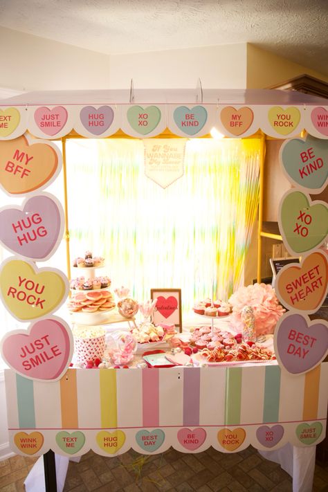 Food table setup at valentines party with heart backdrop and food on the table Valentines Candy Table, Valentines Conversation Hearts Decor, Conversation Heart Decor, Conversation Hearts Decor, Diy Craft Party, Sweetheart Dance, Hearts Decor, Galentine's Party, Valentine Tablescape