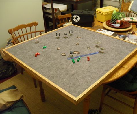 I built a 37 1/2' x 37 1/2' gaming table top, this is to be used for Miniature Games, Board Games, and anything that might require having to move it out of the way to use the table for meals. This a portable table top that games can be set up on and carefully moved out of the way and se...  Tip from the comments: Use  Automotive headliner which has foamy backing, is cheaper, and lasts longer(?). Diy Board Game Table, Diy Gaming Table, Top Board Games, Board Games Diy, Wargaming Table, Build A Table, Toppers Diy, Diy Table Top, Gaming Table