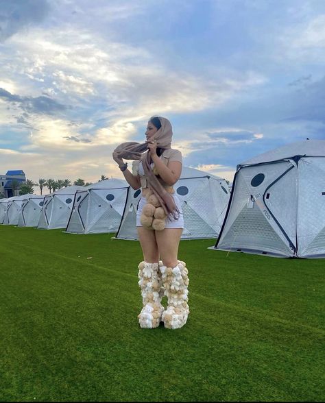 Woman wearing a white crop top and mini skirt with a tan cropped button-up, teddy bear purse, and boots covered in tiny teddy bears. A tan pashmina over her head. Teddy Bear Rave Outfit, Winter Rave Outfits Festivals Cold, Bear Rave Outfit, Brown Rave Outfit, Winter Festival Outfit Cold, Snow Bunny Rave Outfit, Festival Outfits Cold Weather, Teddy Bear Boots, Countdown Rave Outfit